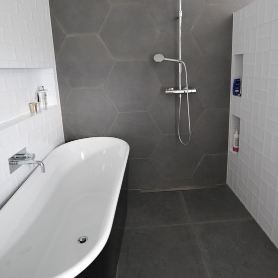 Nytt bad med mørkegrå fliser, hvitt badekar og moderne dusj i stål